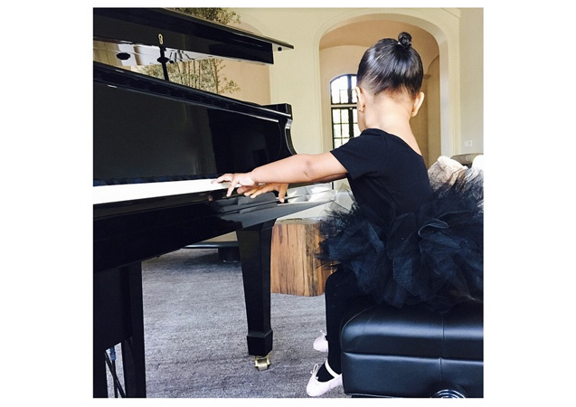 North takes after her dad's musical talent. Here she plays the piano in a high fashion, black tulle skirt. 